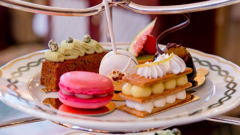 A luxurious afternoon tea spread in London featuring elegant pastries, macarons, and delicate desserts, perfect for a unique tea experience.