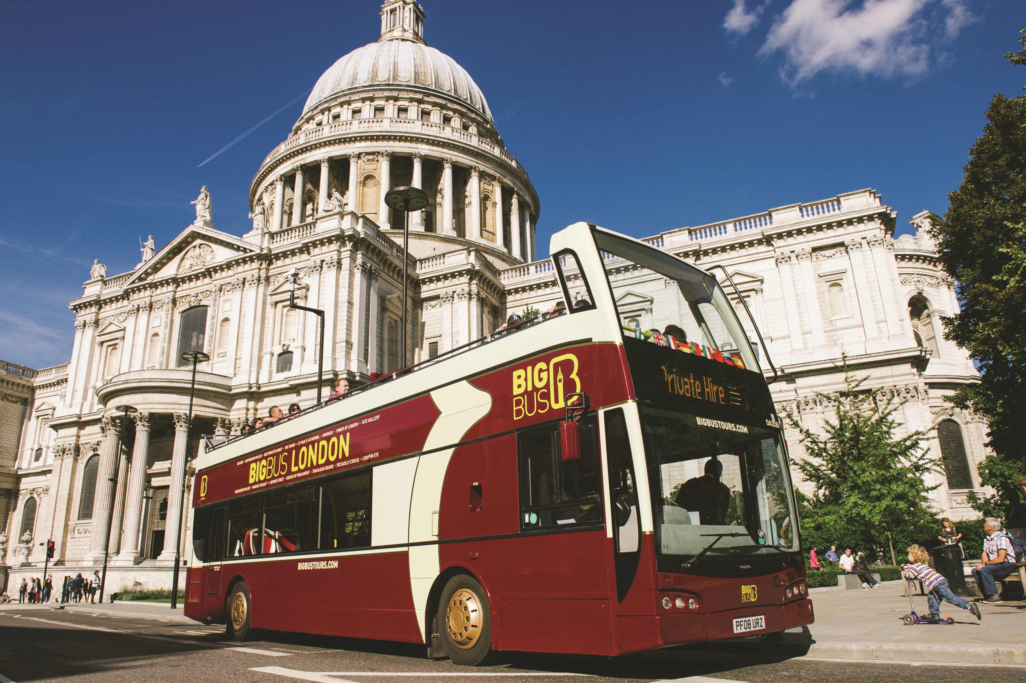 A bright red City Sightseeing London double-decker bus on a sunny day, offering one of the best London city bus tours with scenic views.